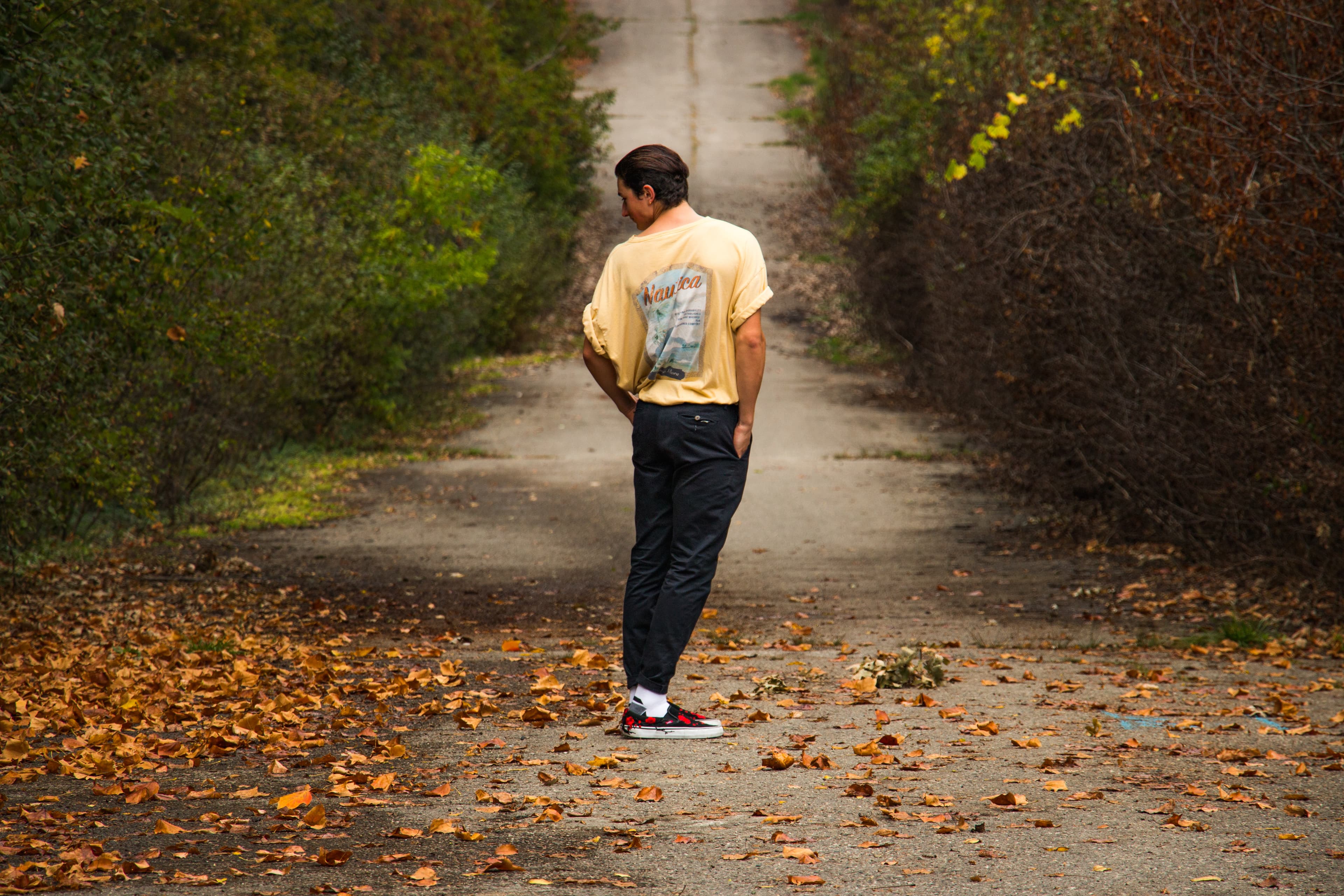 A man in a yellow shirt looking down a hill