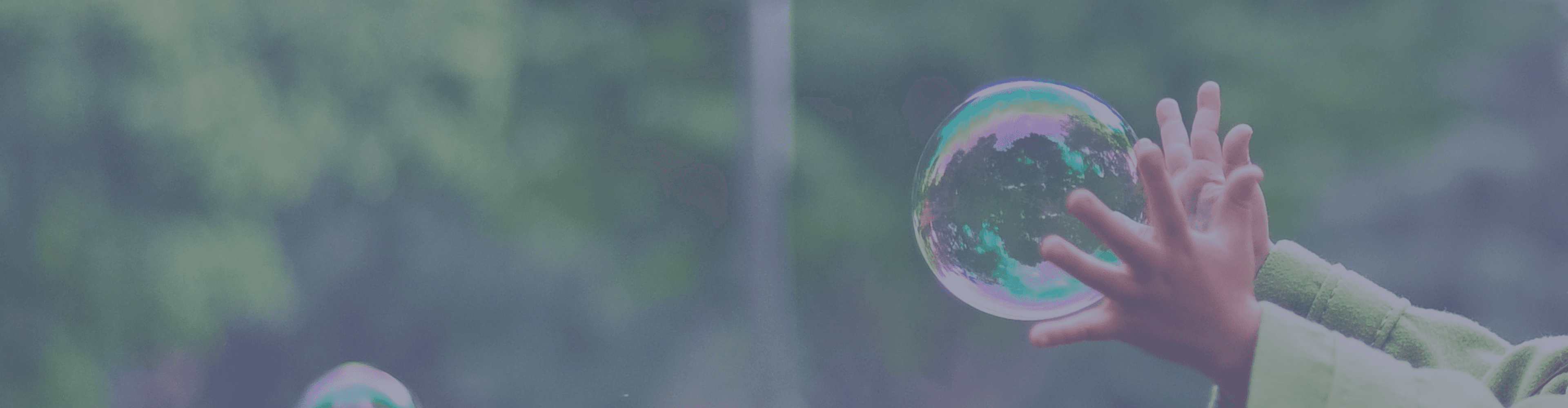 A photograph of a child reaching out to a large bubble